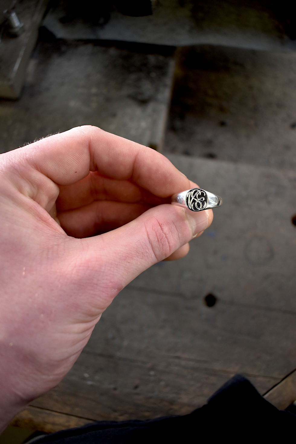 Hand holding monogram engraved signet ring