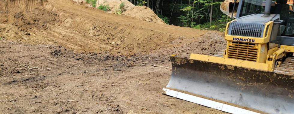 A Komatsu bulldozer working on building a dam for a pond installation in Martinsville, IN