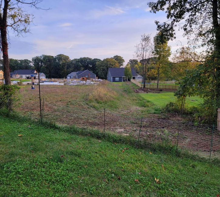 Cleared property ready for fence installation after brush removal in Bloomington, Indiana.