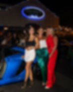 3 Girls standing in front of an exotic car outside of Cuzin's Seafood Clam Bar Marlboro