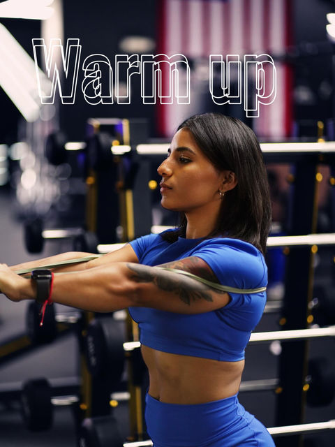 Warm up. Woman stretching with band in gym. | Alpha Gym Fitness | Orlando, Fl