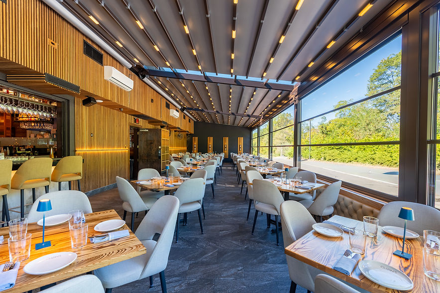 Modern restaurant patio with retractable roof and large windows