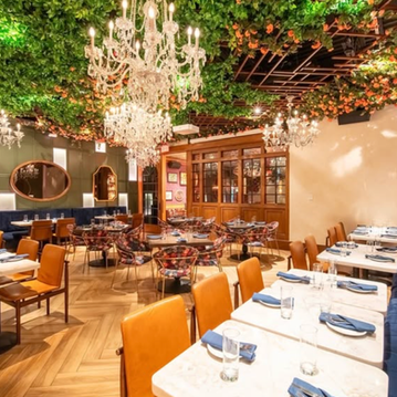 Elegant restaurant dining room with chandeliers and greenery