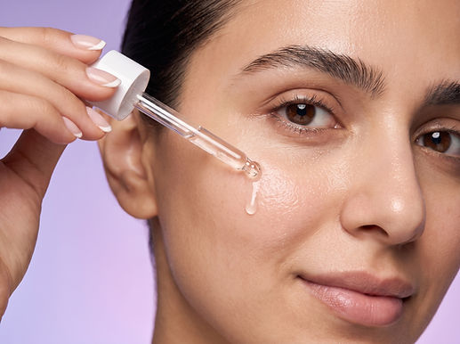 a close up of a woman applying serum