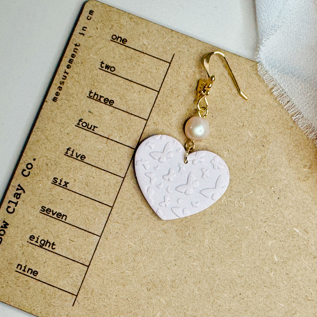 Butterfly Elise earrings on measurement card for size reference