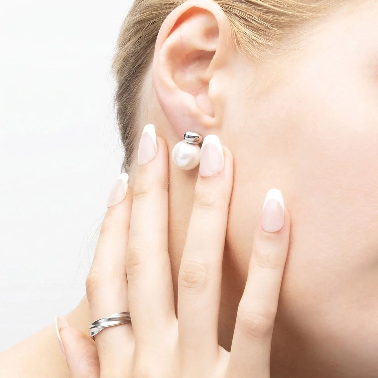 Model wearing the Glass Pearl Stud Earrings in Polished SS