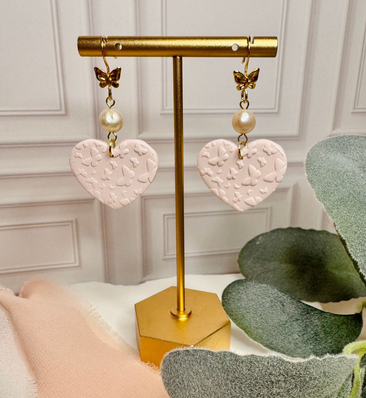 Butterfly Elise earrings with pink heart drop, pearl accent, and gold butterfly detail
