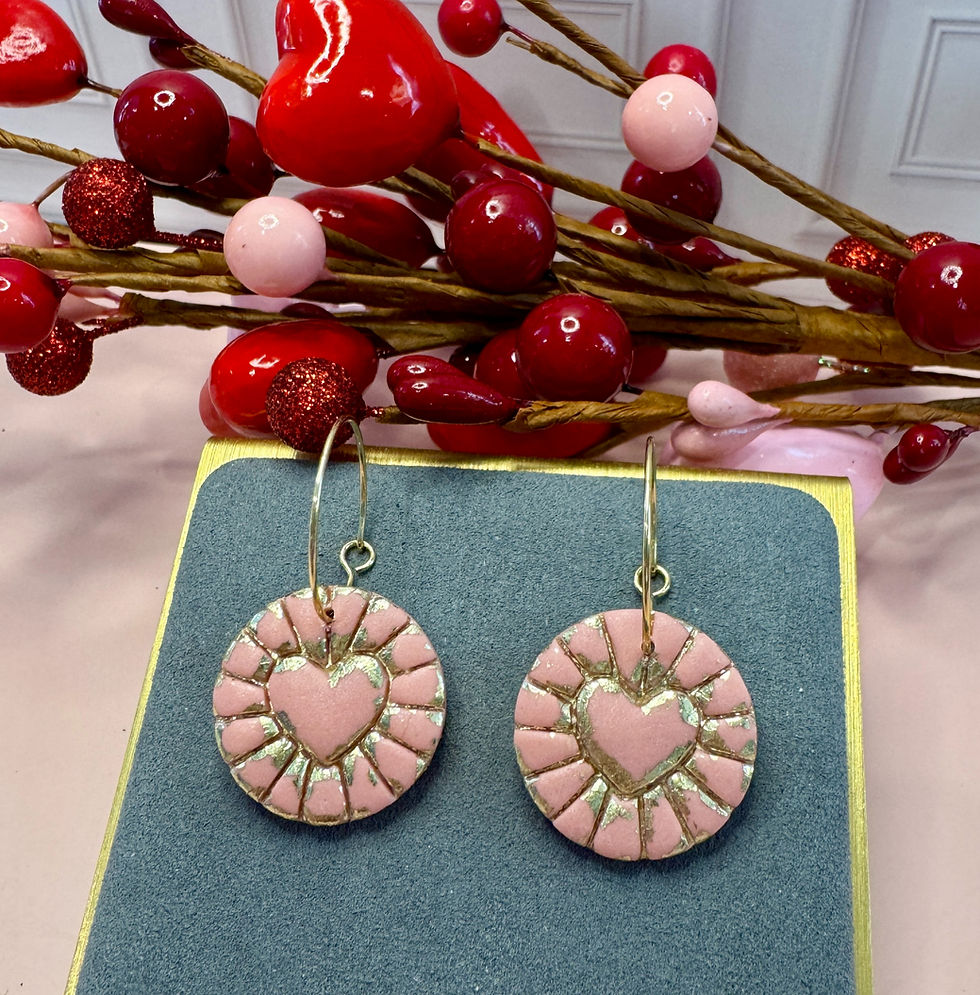 Round coin shaped earring with an embossed gold foil heart on earring display.