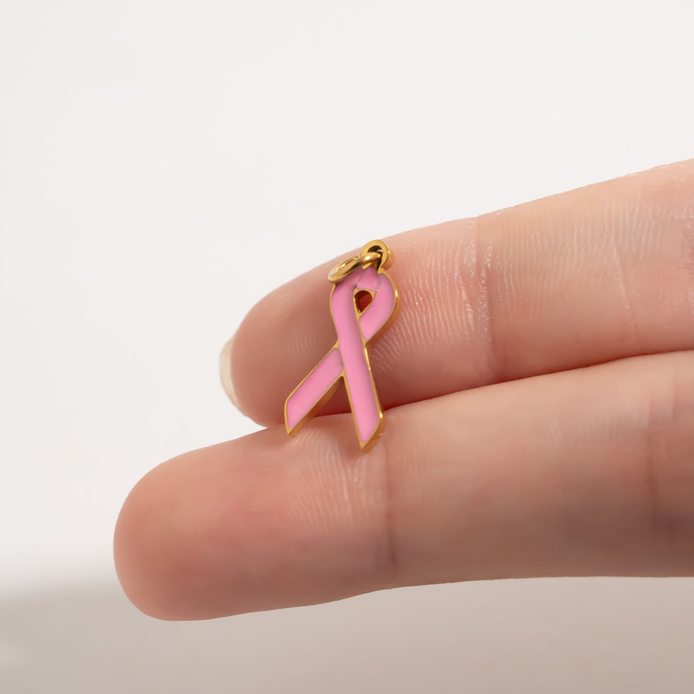 Pink Breast Cancer Ribbon Charm shown in 18K Gold PVD Plated Stainless Steel against fingers for size comparison.