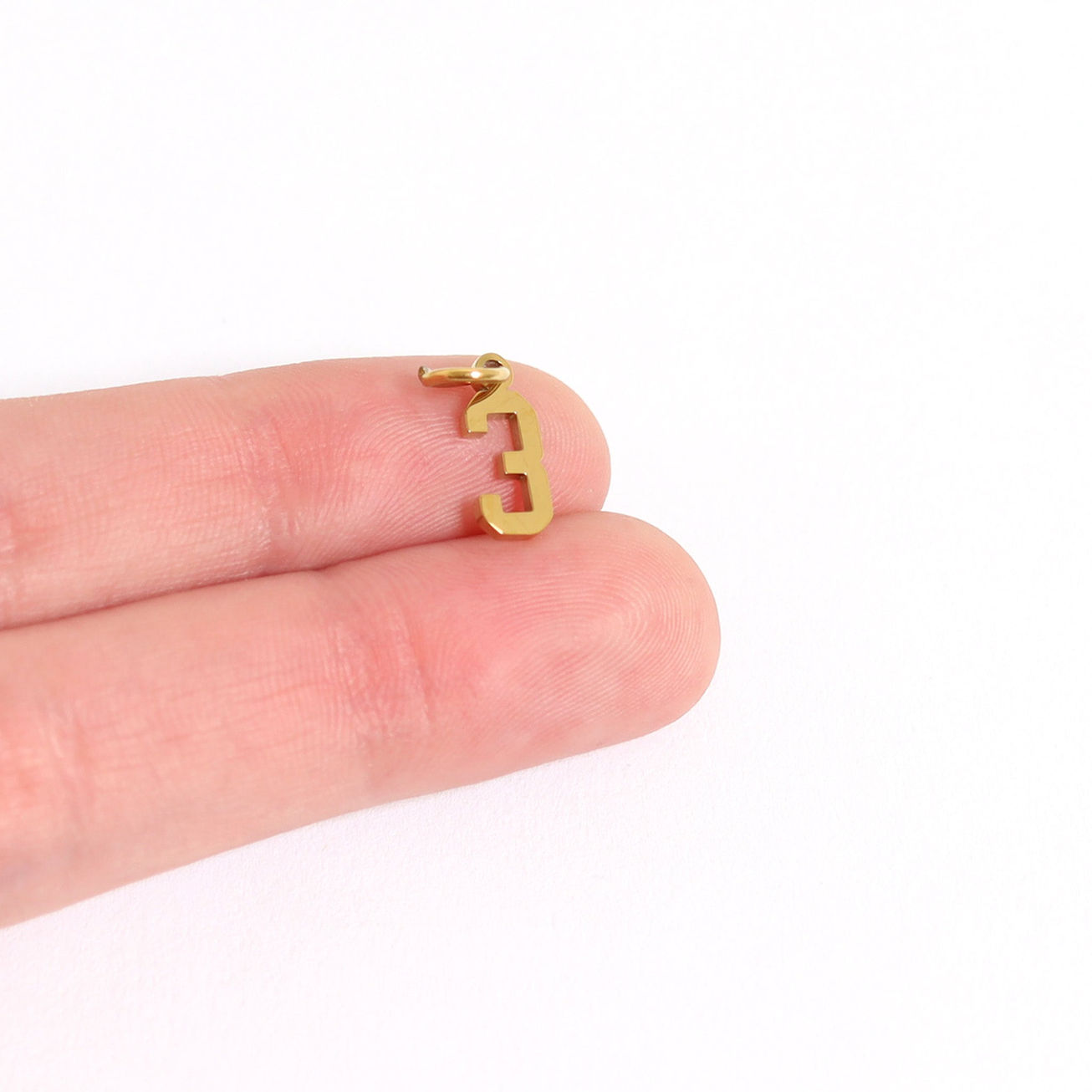 Jersey Number Charm #3 shown on finger for size in 18K Gold PVD Plated Surgical Stainless Steel