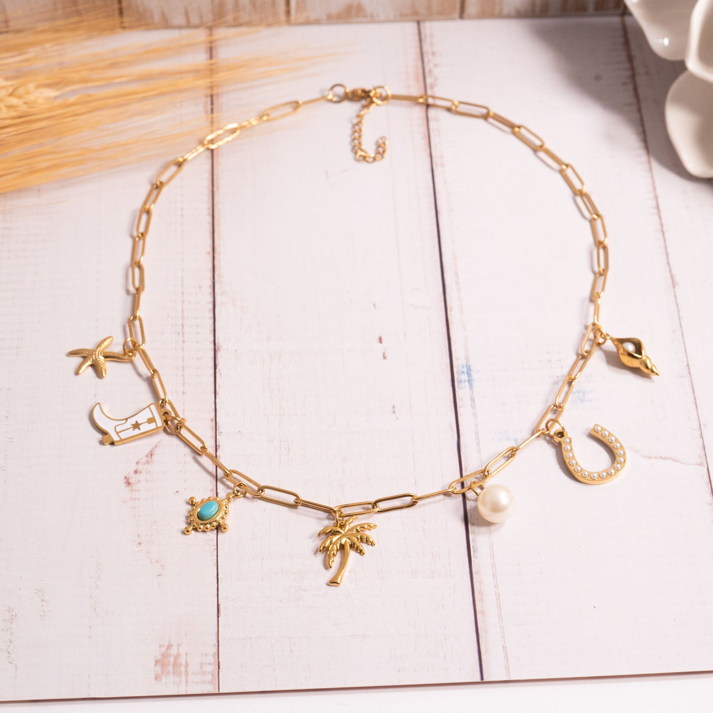 Pearl Horseshoe Charm shown in gold finish shown on paperclip charm necklace with other charms