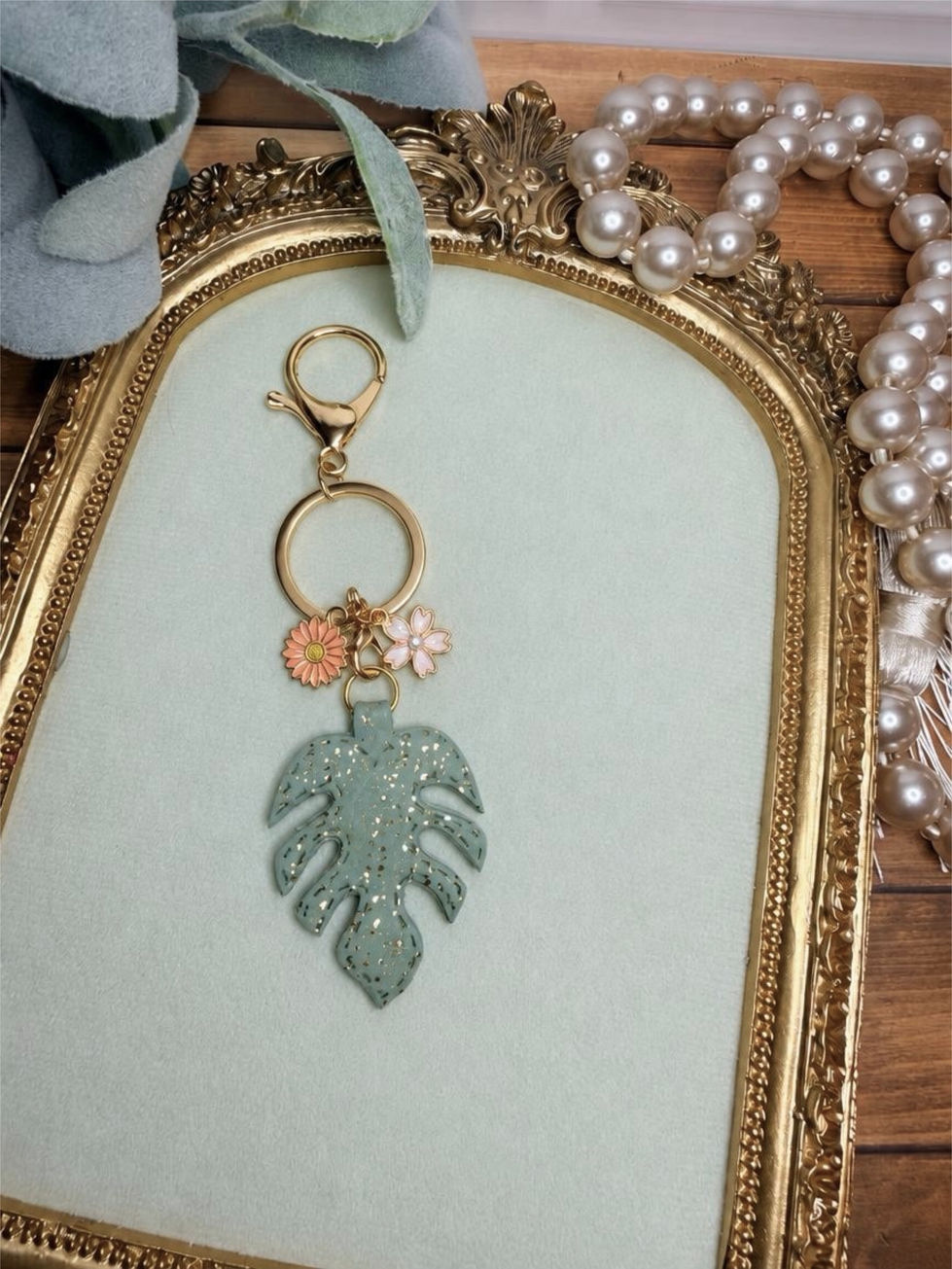 Handmade Golden Monstera clay key ring with sage green leaf, gold details, gold-tone hardware, and coordinating accent charms