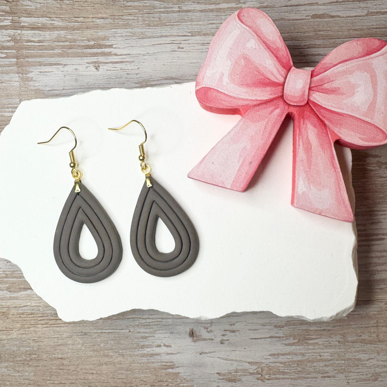 Elizabeth | Sculpted Polymer Clay Earrings (Stone) displayed on stone with pink bow.