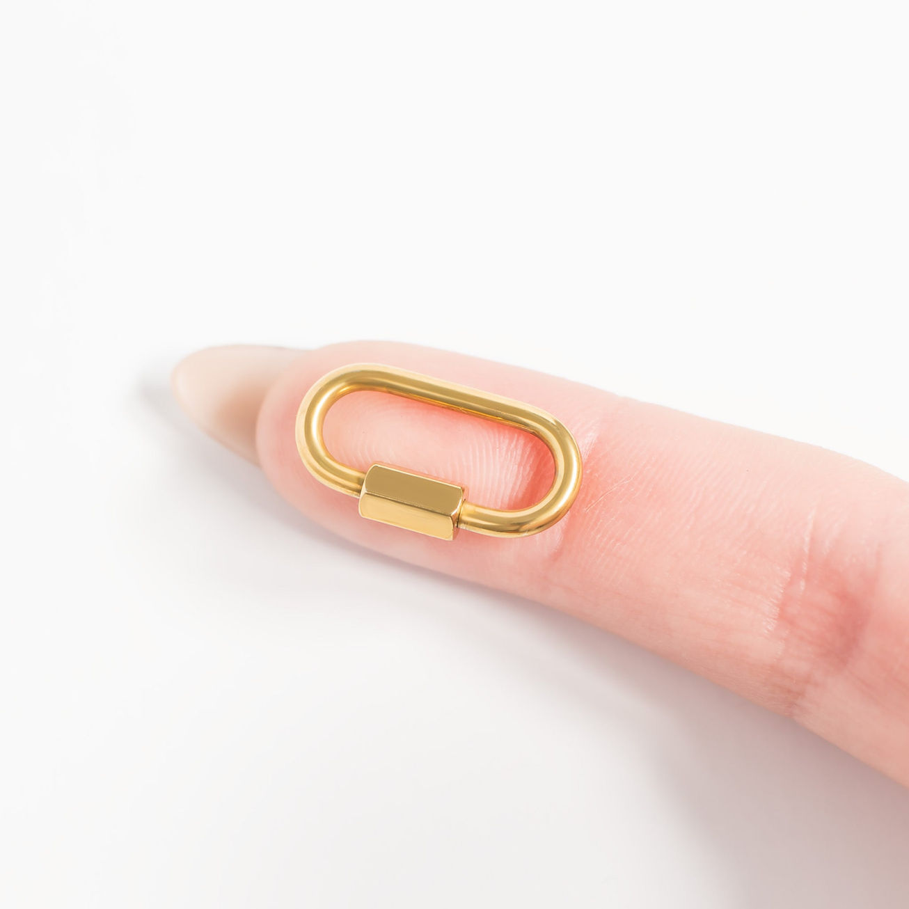 Carabiner Charm Holder shown in 18K Gold PVD Plated SS against finger for size comparison