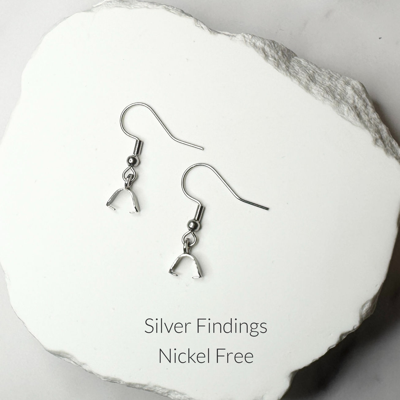 silver-tone fishhook ear wires displayed on white stone