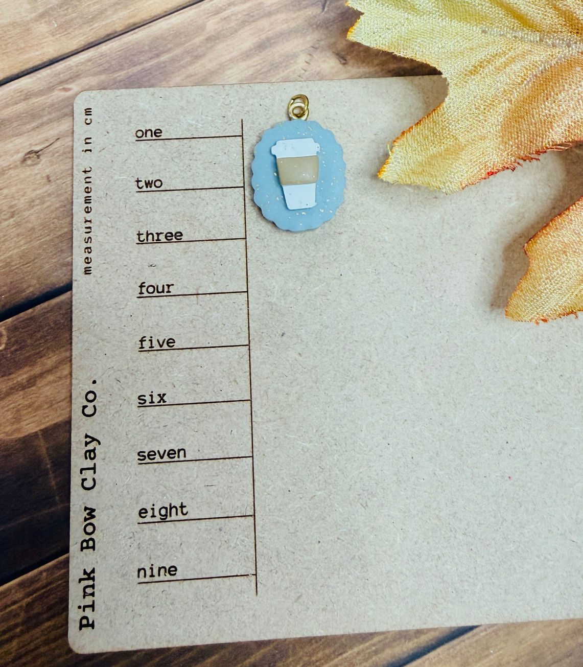 Cozy Cup - Polymer Clay Charm shown on size board