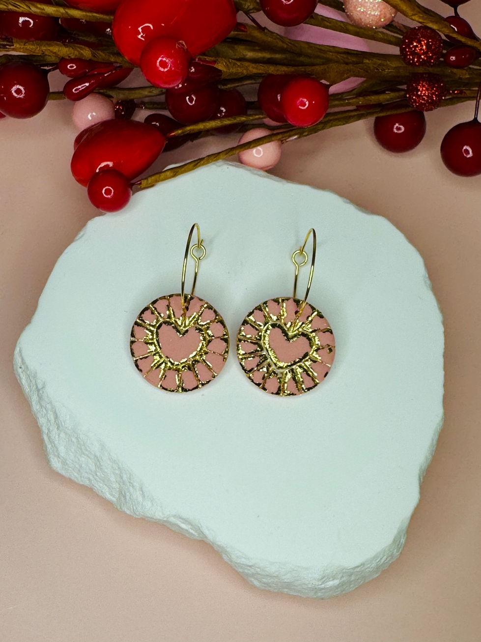 Round coin shaped earring with an embossed gold foil heart.