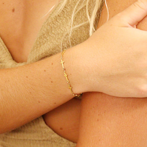 Gold Cross Station Bracelet worn on a woman’s wrist