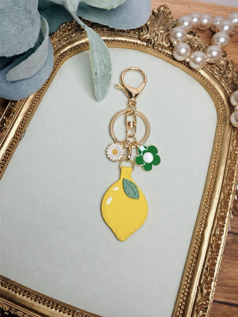 Handmade Lemon Drop clay key ring with yellow lemon, green leaf, gold-tone hardware, and coordinating charms.