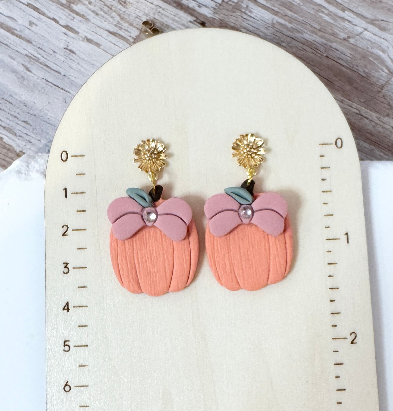 Pumpkin Bow Bloom | Polymer Clay Earrings with gold plated flower stud shown on ruler board