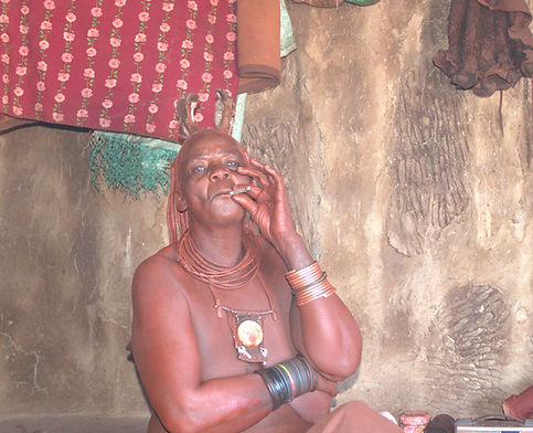 Himba woman smoking, near Opuwo, Namibia
