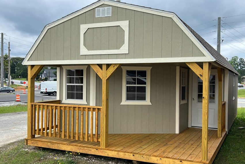 Deluxe lofted cabin with inset porch and metal roof, shown from a side angle with porch posts and railing