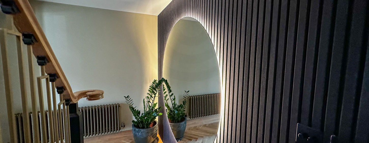 Vertical timber slat wall with coat hooks in Chingford stair area