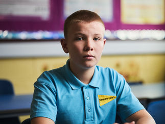 A Ukrainian boy sitting at a school desk in Scotland