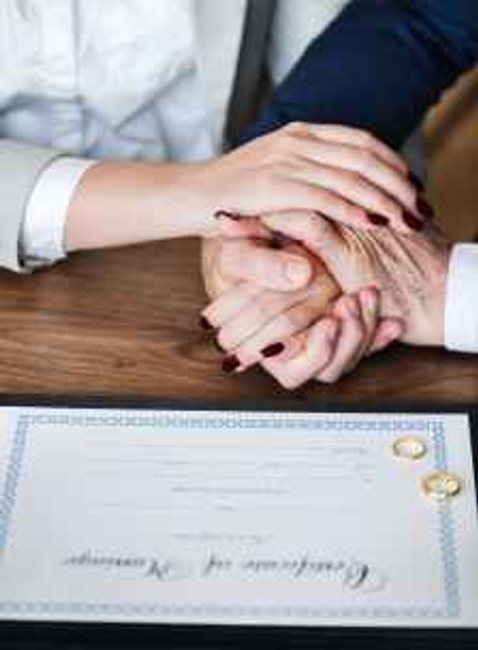 man and woman holding hands on brown wooden table