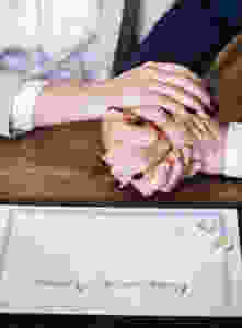 man and woman holding hands on brown wooden table