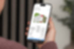mockuuups-iphone-15-pro-mockup-in-a-mans-hand-against-an-indoor-background.jpeg
