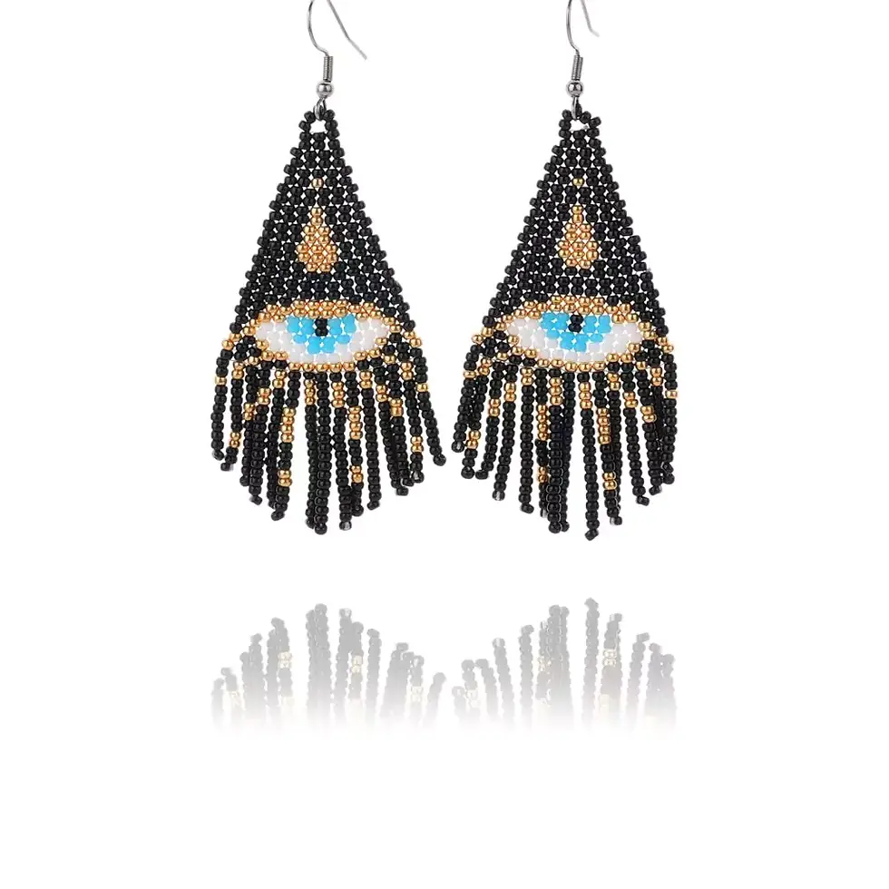 LANCUI's beaded earrings with a blue eye design, featuring black, gold, and white beads. Set against a white background, with reflections below.