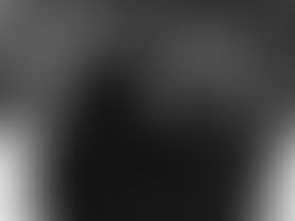 Two people in winter coats walk arm-in-arm in a snowy park with tree-lined paths and vintage lampposts, exuding warmth and companionship.