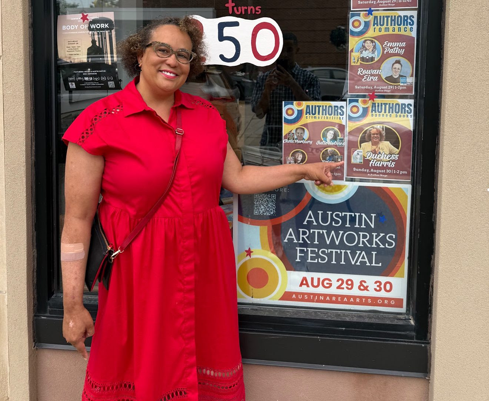 African-American author pointing to her book promotion in a street window