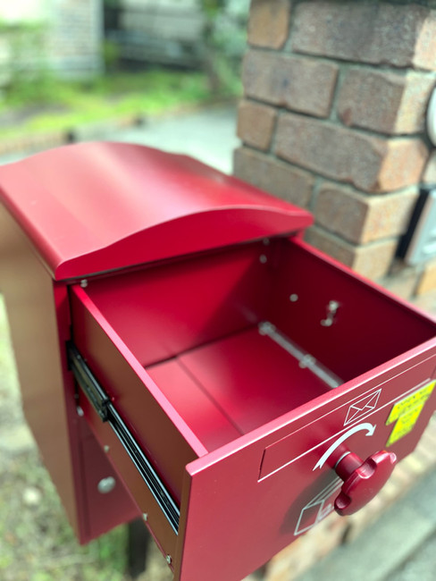 戸建て玄関前に設置された赤い宅配ボックス。レンガ調の門柱や外観と調和し、不在時でも安心して荷物を受け取れる便利な宅配ボックスです。