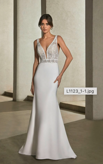 A sleek mermaid gown featuring a flared crepe train, paired perfectly with an open back for a flattering bodice.
