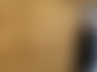 A person walking by a wall of framed artworks.