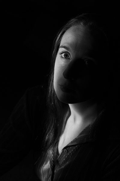 zwart-wit potret van een vrouw die schuin omhoog kijkt