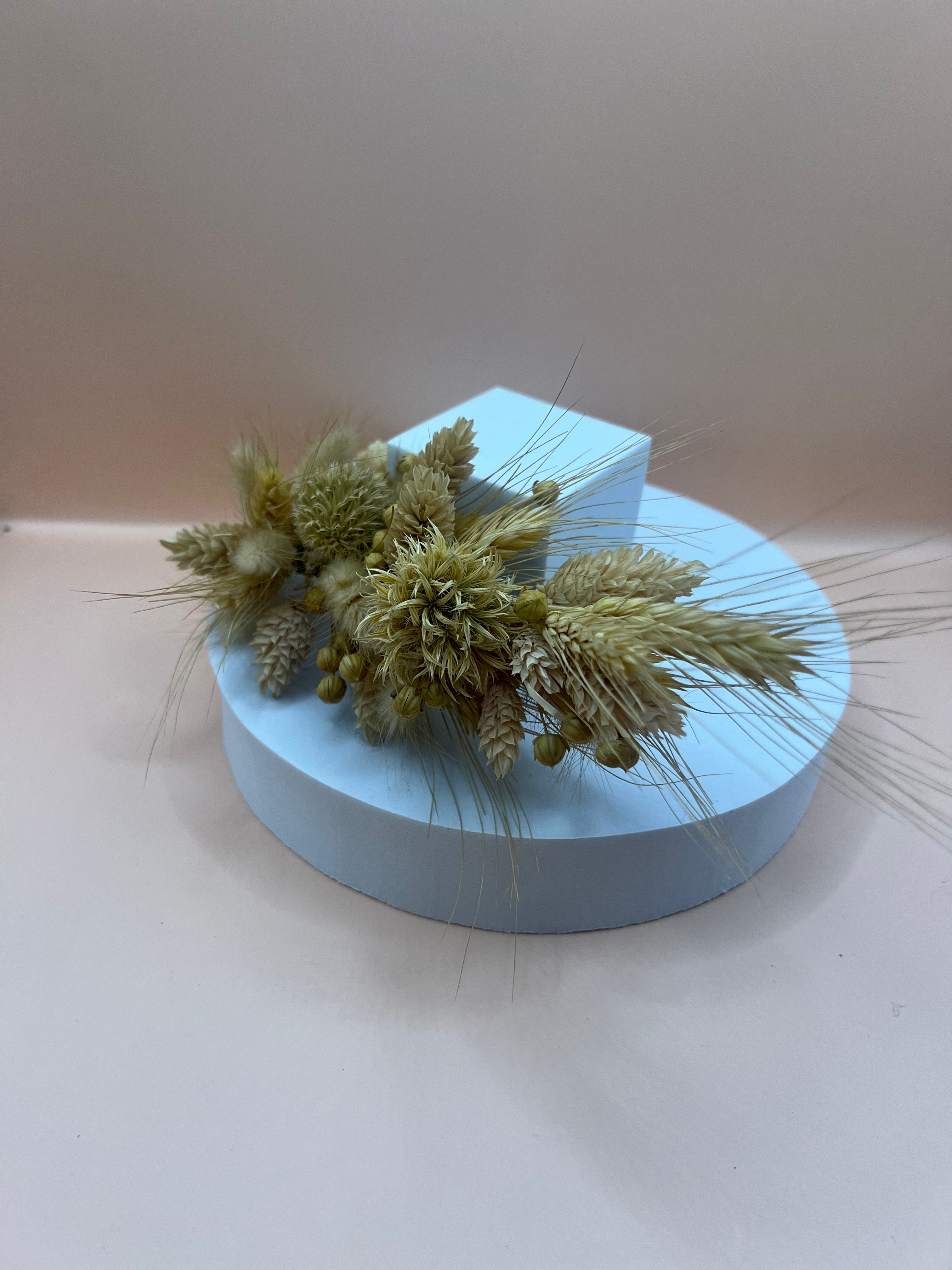 Der Haarschmuck aus Trockenblumen wird auf einem Podest präsentiert.