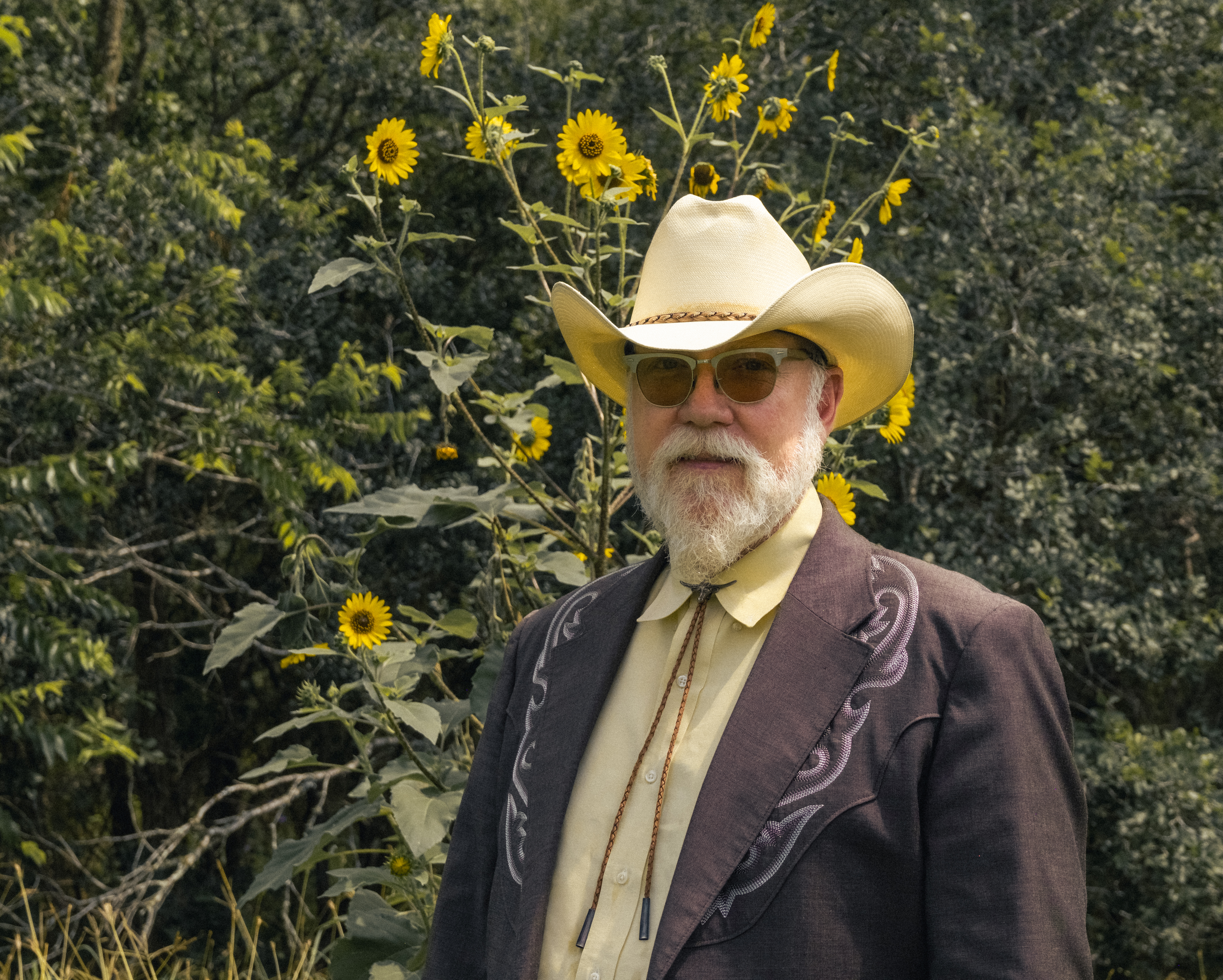Portrait of Joe Don standing in front of sunflowers