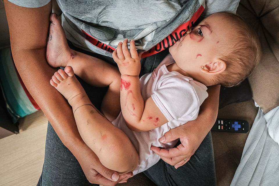Amamentação em Curitiba, fotógrafo Zé Américo registra criança toda pintada de tinta guache enquanto toma mamá no peito da mãe em casa