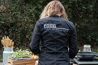 Chef in 'Food For Athletes' outfit cooking, showcasing sports-specific catering services at Arrivée.
