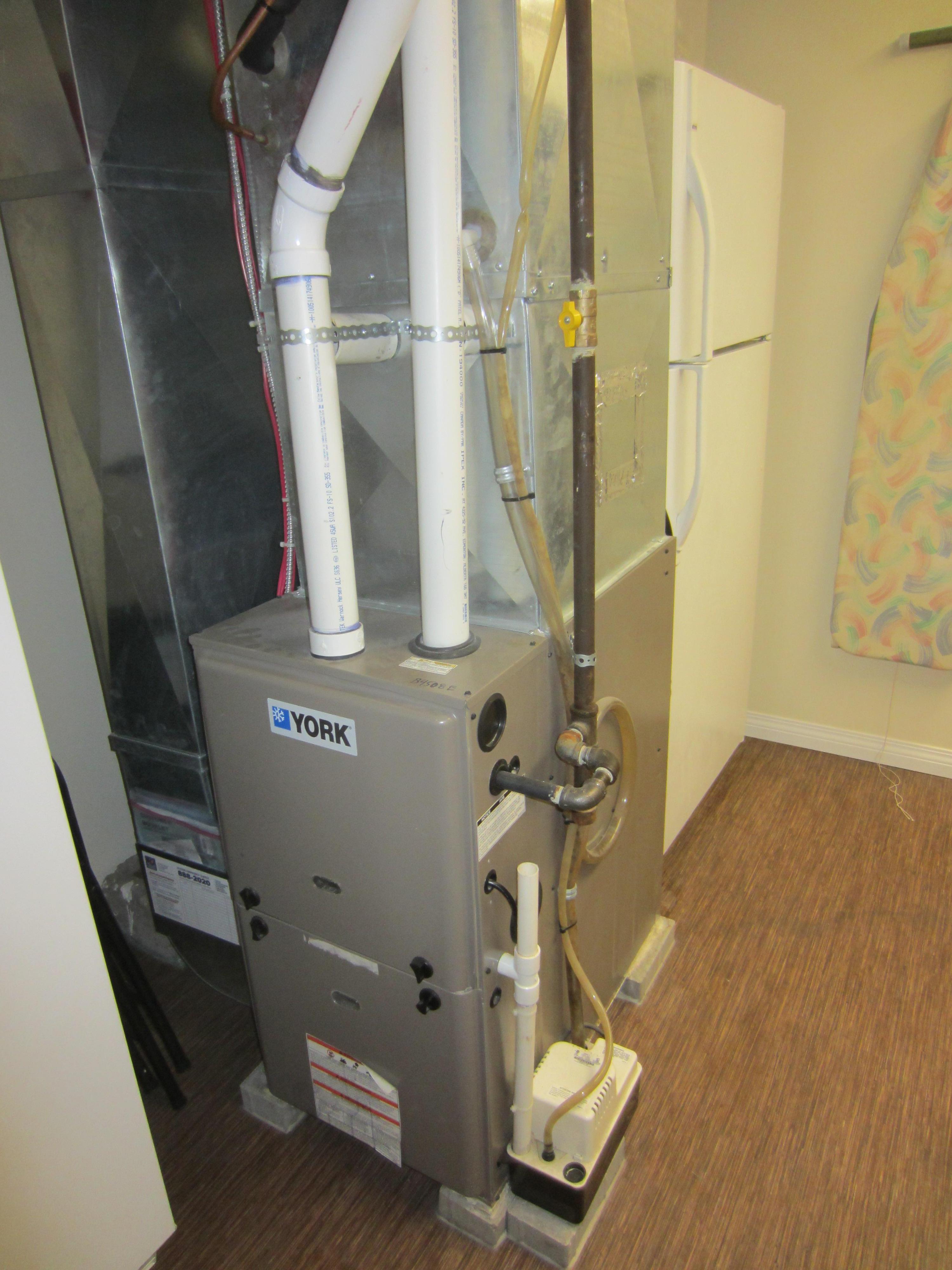 Condensing forced-air gas furnace with supply and return ducts and PVC vent pipes