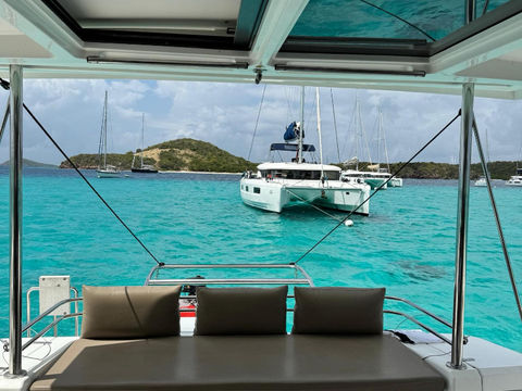 View from the yacht's helm station with another yacht on the turquoise sea in the background.