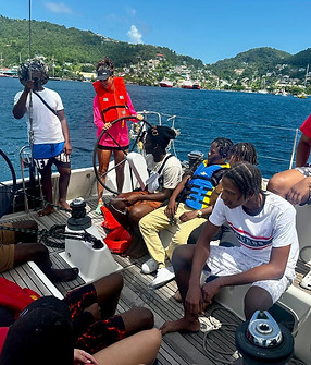 The launch of the Yputh Yacht Charter Program with students on board a monohull student and instructor at helm.