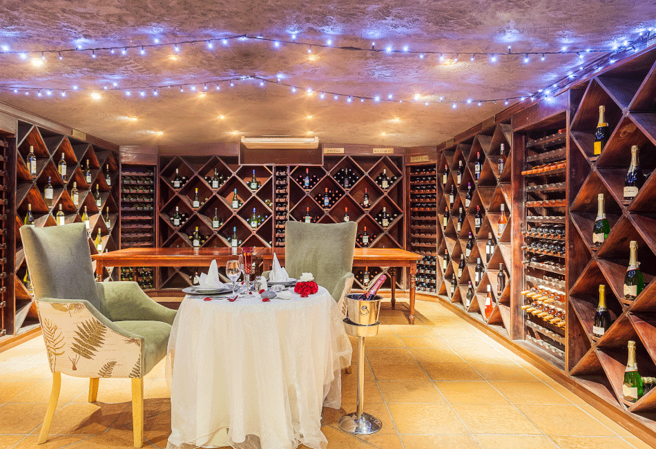 A brightly lit wine cellar with a table adorned with a white table cloth.
