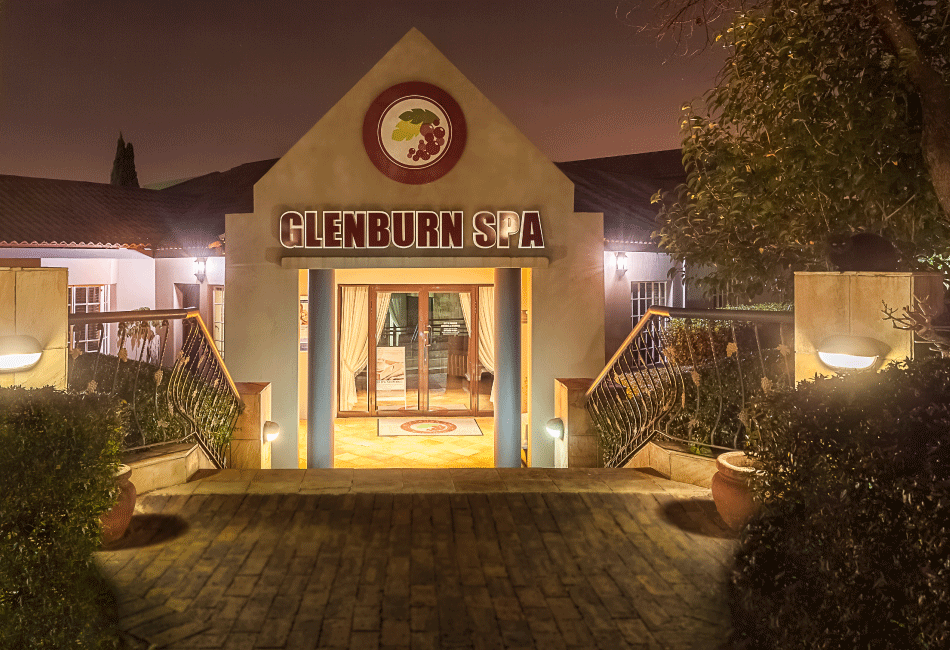 The entrance of a wellness spa illuminated by lights at night.