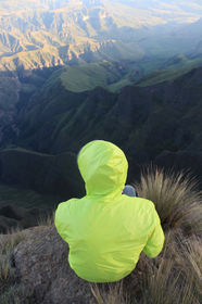 Hiker sitting on the edge of the Amphitheatre in the Drakensberg.