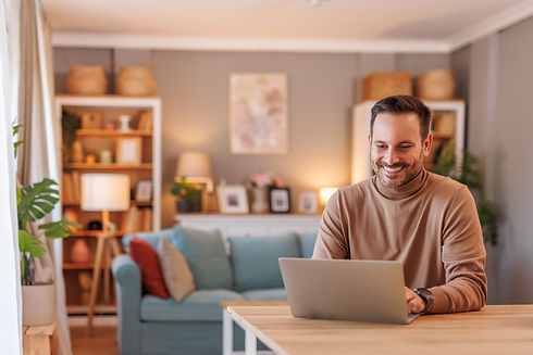 portrait-businessman-smiling-analyzing-data-laptop-while-working-desk-home-office.jpg