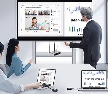 Office meeting with three people viewing a wall display and laptops showing charts and a video call, with year-end wrap-up text.